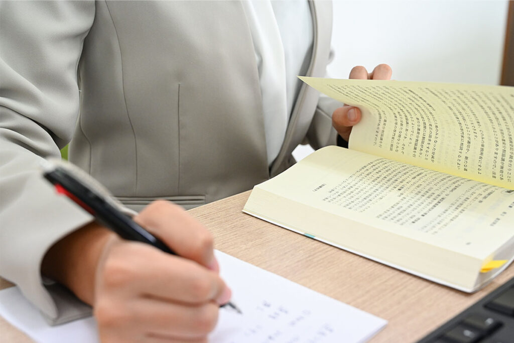 書籍を見ながらメモをする様子